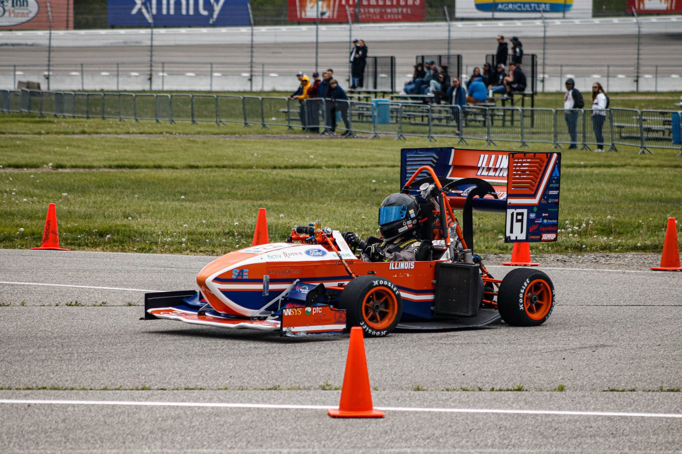 The Formula SAE car racing past the grandstand